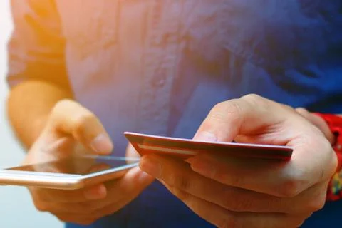 Close up of young man use smart phone and holding credit card, shopping onl.. Stock Photos