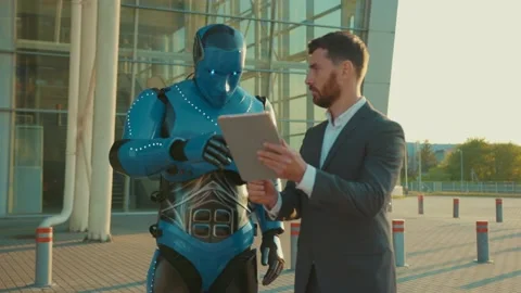 Close up young man use tablet computer talking with humanoid robot shows the way Stock Footage 133299303