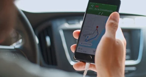 Close-up young man using navigation map application on smartphone hand on wheel Stock Footage 119296243