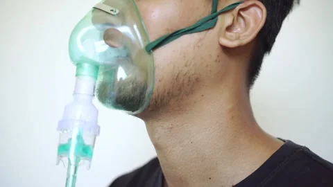 Close up Young man using nebulizer for asthma and respiratory diseases at home Stock Footage 322109881