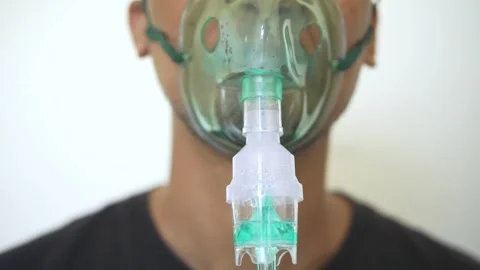 Close up Young man using nebulizer for asthma and respiratory diseases at home Stock Footage 322109883