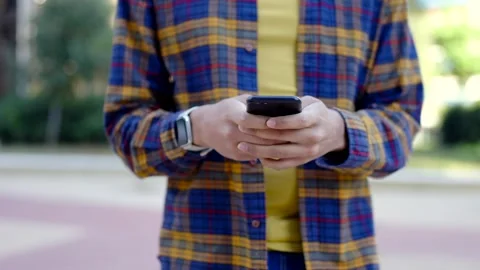 Close-up of a young man using phone while walking outdoors Stock Footage 258326267