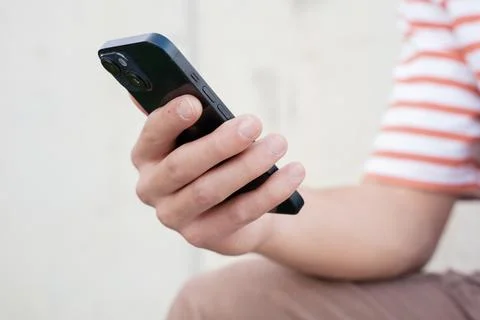 Close up of young man using smartphone app outdoors. Stock Photos