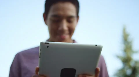 Close up of a young man using a tablet outside Vidéo 57502564