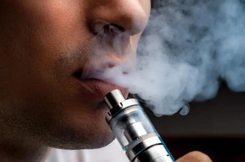 Close-up - young man vaping e-cigarette Stock Photos