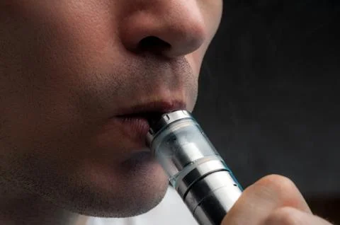 Close-up - young man vaping e-cigarette Stock Photos