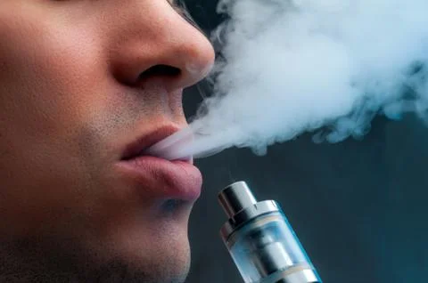 Close-up - young man vaping e-cigarette Stock Photos