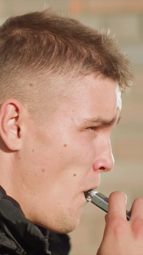 Close up young man vaping electronic cigarette facial details skin texture soft Vídeo Stock 345060049