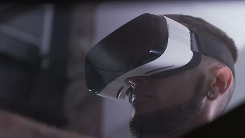 Close-up of young man in virtual reality goggles looking around. View from below Stock Footage 98181561