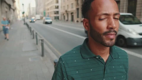 Close-up of young man walking down the street next to the road 스톡 동영상 227092488