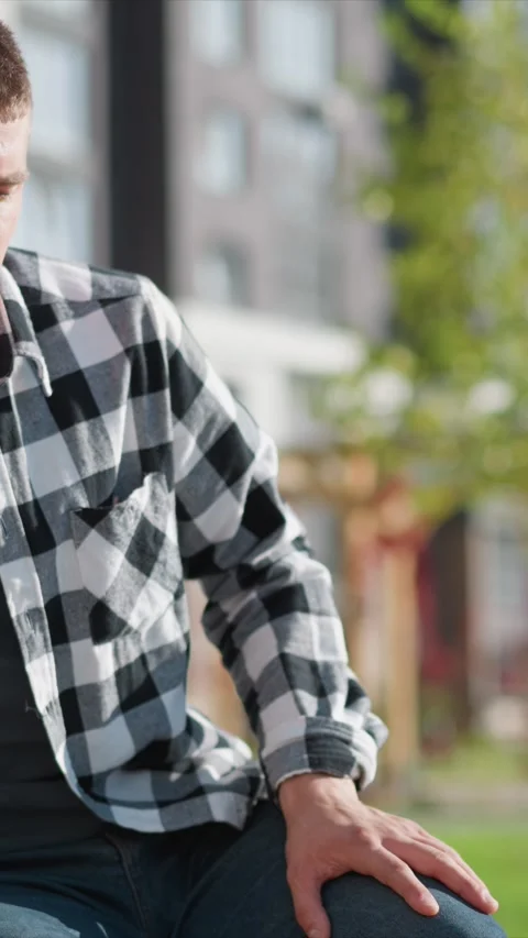 Close up of young man wearing black and white checkered flannel shirt sitting Stock Footage 345051729