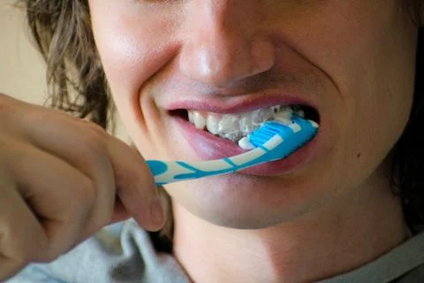 Close-up of a young man while brushing his teeth, personal hygiene. Young man Stock Photos