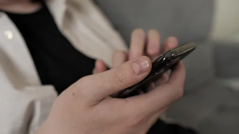 Close up young man worker sitting holding mobile phone in hands texting message Stock Footage 255323014