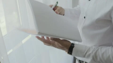 Close up of Young man worker taking notes standing in office. Stock Footage 139507475