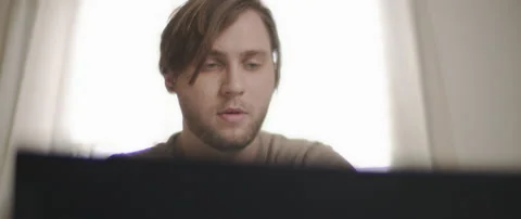 A close up of a young man working on a computer from home. Stock Footage 135095718