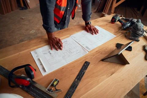 Close-up of young man working next to digital tablet and tools in woodworking Stock Photos