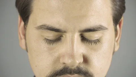 Close up of young man's eyes opening. Grey clean background Stock Footage 76203361