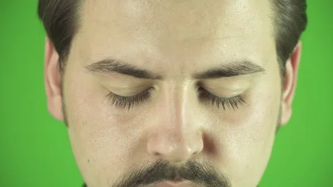 Close up of young man's eyes opening. Greenbox background. 스톡 동영상 76399450