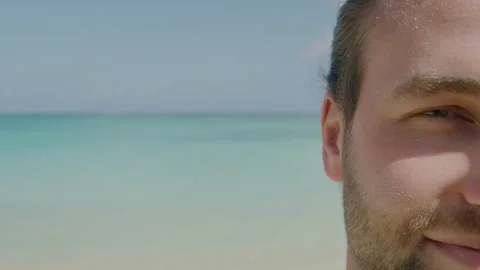 A close up of a young mans face burned on the beach with the ocean in the Stock Footage 264086691