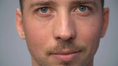 Close-up young man's face lightly smiling Stock Footage 70486358