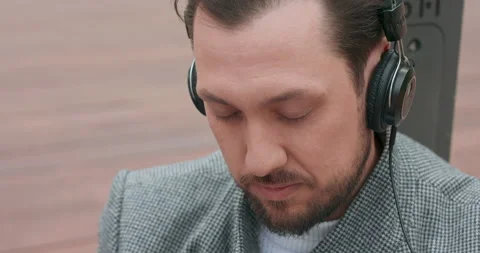 Close up of young man's face, with mustaches and a beard, who sits on the wooden Stock Footage 140237671