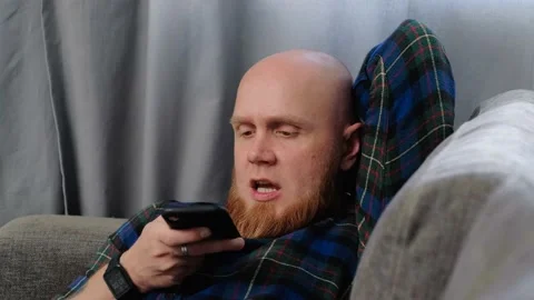 Close-up of young man's face recording voice message on smartphone. Stock Footage 139647672