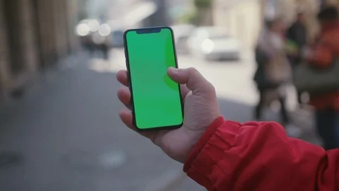 Close-up of young man's hand browsing on vertical smartphone greenscreen mock-up Stock Footage 117429347