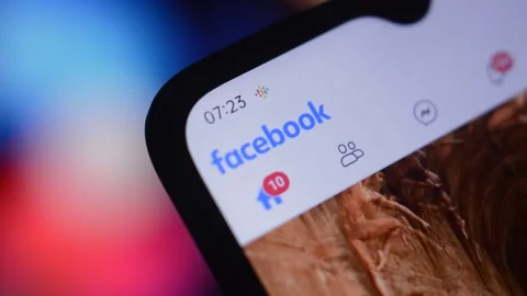 Close-up young man's hand scrolling facebook social network app by meta. 動画素材 219929001