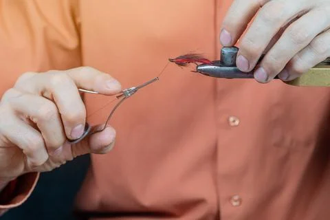 Close up on young man's hands tying a fly for fishing Stock Photos