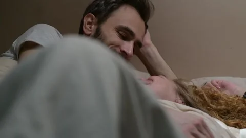 Close up of a young married couple in bed sharing an intimate moment. 库存影片 329939836