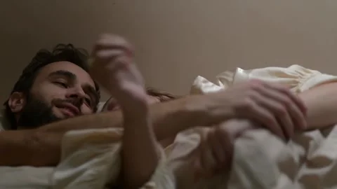 Close up of a young married couple lying in bed and embracing. 库存影片 329939844