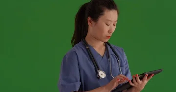 Close-up of young medical assistant using tablet pc to take notes on greenscreen Vídeos de archivo 85493894