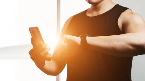 Close up of young men After a workout session, check your workout results wit Stock Photos