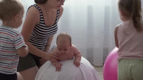 Close-up young mom joyfully do exercise, masah with newborn kids Stock Footage 142060654