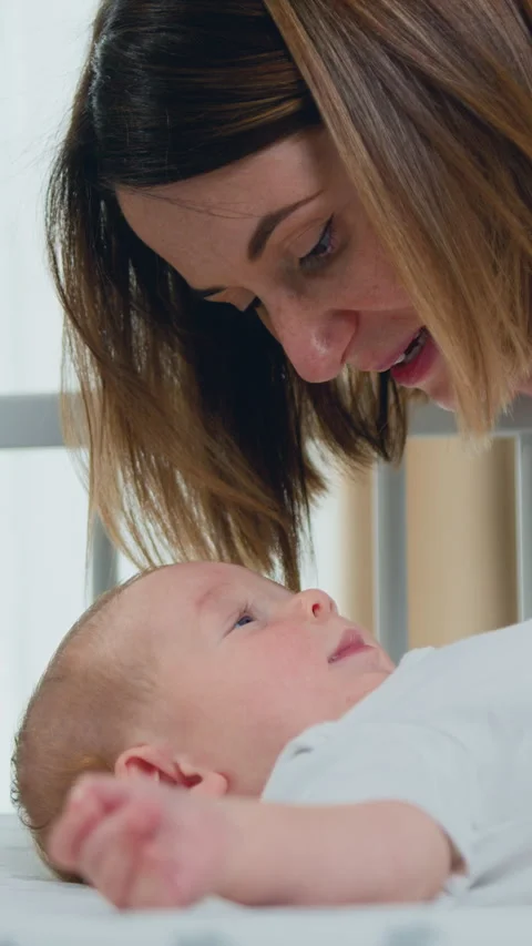 Close up of young mother hugging and kissing her adorable few month baby resting Stock Footage 327451133