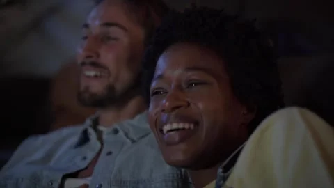 Close up of young multi-ethnic couple laughing out loud watching movies TV at Stock Footage 248866016
