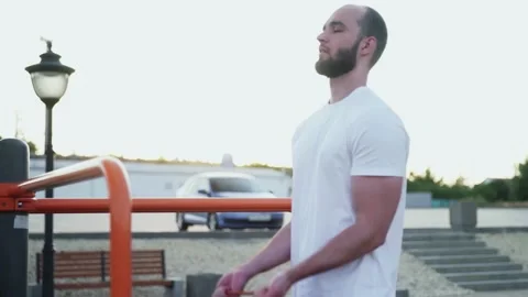 Close up of young muscular man doing exercises with elastic band outdoors Video stock 143503473