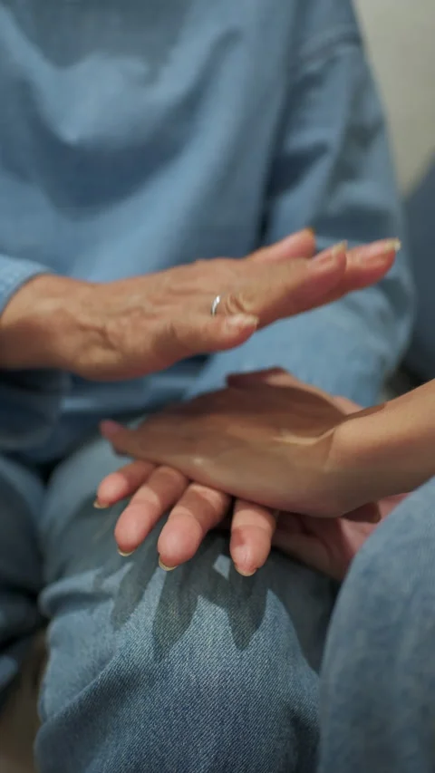 Close-up of a young person holding hands with an elderly woman Stock Footage 346509768