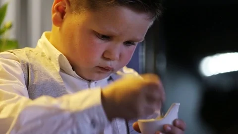 Close up young pretty boy sitting looking eat sweet childhood candy lifestyle Stock Footage 98216015