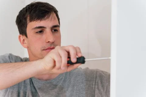 Close-up of a young professional carpenter using a hand-held screwdriver Stock Photos