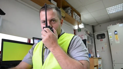 Close-up of young security guard talking on a walkie-talkie 스톡 동영상 119860382