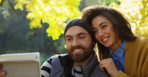 Close up of young smiled couple video chatting on the white tablet computer and Stock Footage 82509975