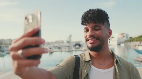 Close up, young smiling man dressed in an olive color shirt makes video call Stock Footage 226849424