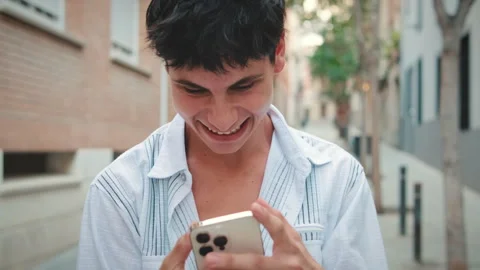 Close up, young smiling man using mobile phone outside Stock Footage 253937110