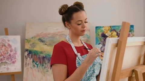 Close up of young smiling painter making her new masterpiece on canvas Stock Footage 74194812