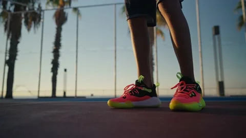 Close-up of young spotsman bouncing basketball ball training on ground floor of Stock Footage 207120018