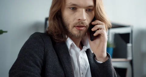 Close up of young stylish office manager with long hair talking on mobile Stock Footage 147051299