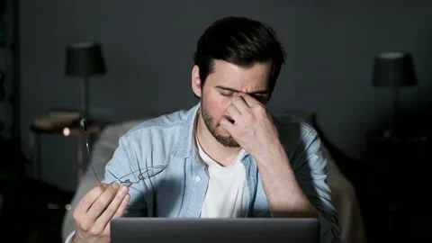 Close-up of a young Tired Man Adjusting his Glasses, Working at Night Online Stock Footage 144378829