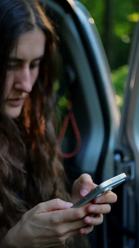 Close-up of a young traveler embracing both technology and the outdoors... Vidéo 340291013