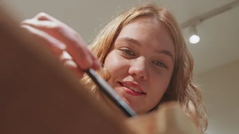 Close up of young woman applying makeup with soft lighting in indoor setting Stock Footage 345086932